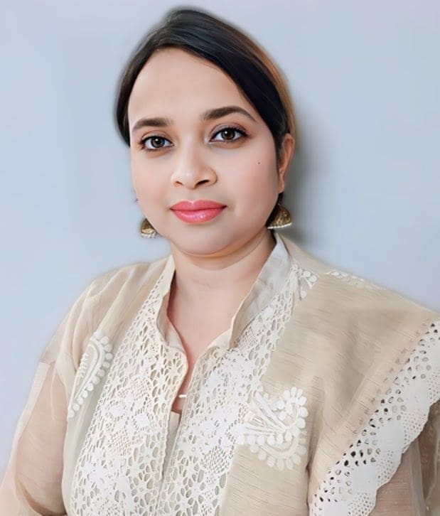 Portrait of a woman wearing a beige embroidered top.